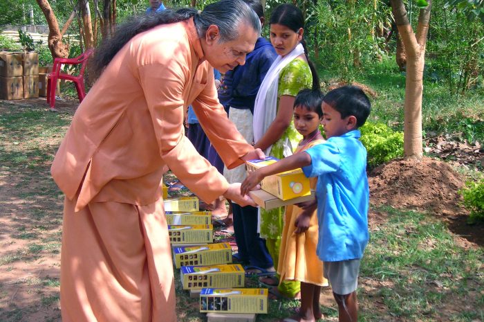 A YSS monk distributes Essential Items to the Needy