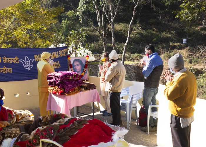 Devotees pray before blanket distribution in Dwarahat.